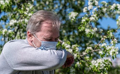 Un hombre con alergia al polen se protege con la mascarilla