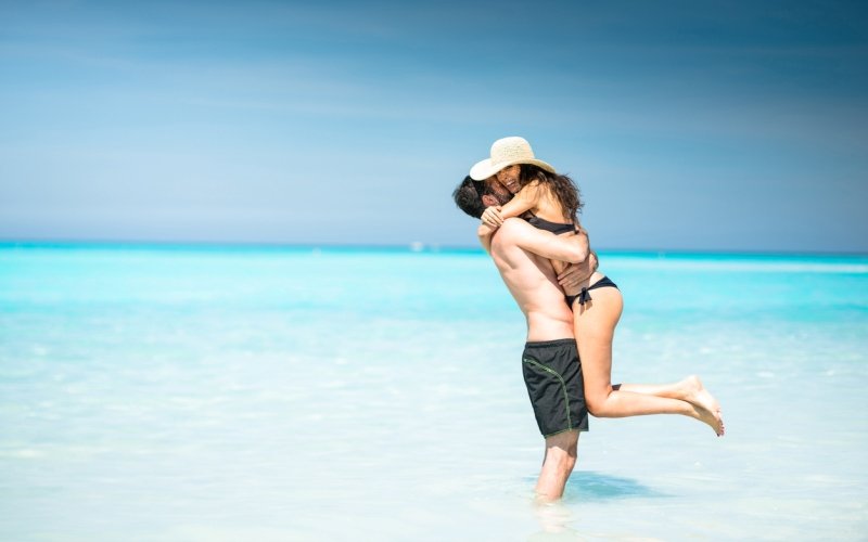 Una pareja se da un abrazo en la playa