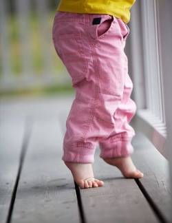 Un bebé, andando de puntillas