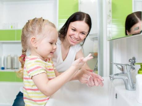 Una niña se lava las manos delante de su madre