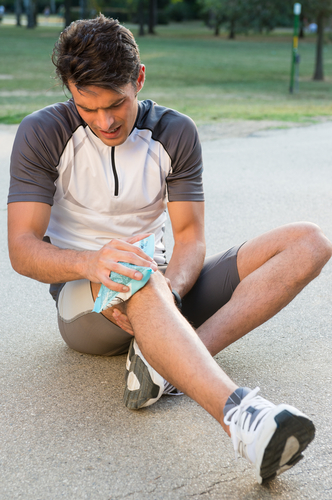 Un deportista aplica una bolsa de hielo en la rodilla para aliviar el dolor