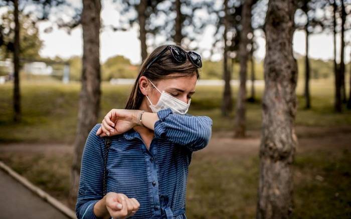 Una mujer se cubre la boca al estornudar como medida de prevención